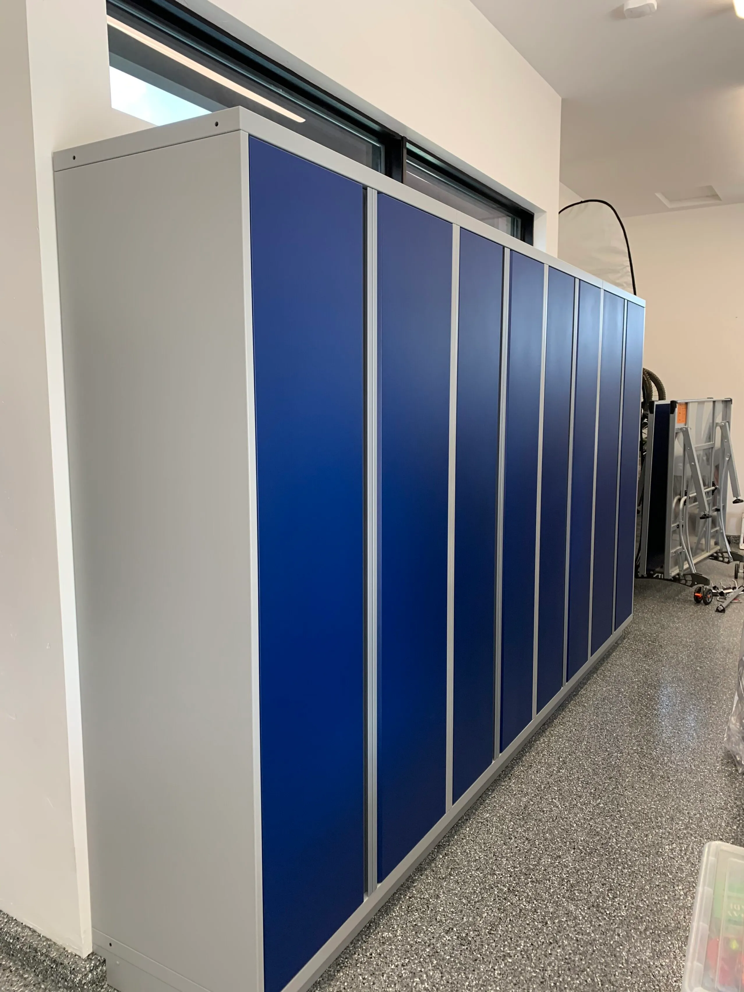Tall blue and silver metal garage storage cabinets by Baldhead Cabinets — high-capacity vertical cabinetry for organized tool and equipment storage in custom garage environments