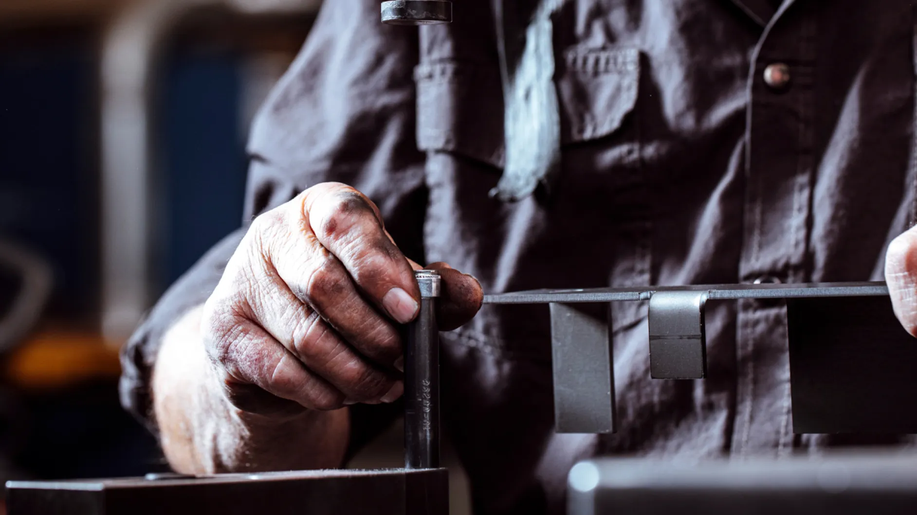 Craftsman assembling metal components at Baldhead Cabinets